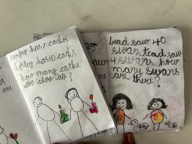 Notebook pages with handwritten number stories and coloured drawings.